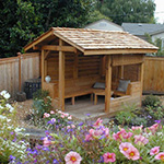 A very small garden structure provides a year round retreat from the sun or rain in this urban backyard built from sustainably harvested wood. Structure & Garden Installation by Apogee Landscapes.